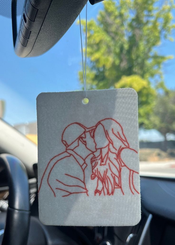 a couple kissing in the back seat of a car with a red marker on it