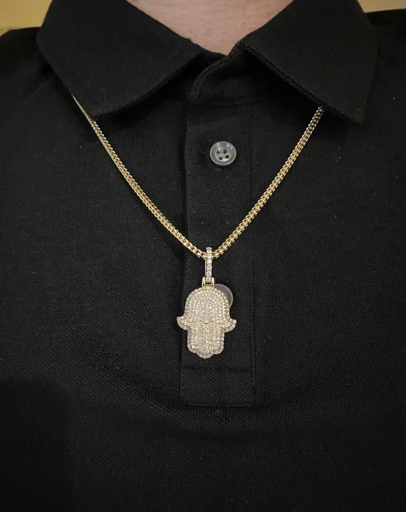 14k solid gold diamond Hamsa Pendant. Material: 14k solid Yellow Gold.Diamonds: 2.50 carats of round brilliant diamonds.Average quality used: VS2-SI1.Average diamond color used: F color.Gold weight: Approximately 9.5 grams.Length: Pendant is Approximately 1 inch long. With diamond bail 1.5 inches long. Width: 0.75 inches wide.Comes with Certificate of authentication.Comes in a nice box.Make it personal. Add a custom engraving to the back of this solid gold pendant. *Chain is sold separately. Mod Cubic Zirconia Diamond Pendant Necklace Hand Set, Hand Set Cubic Zirconia Diamond Pendant Necklace, Cuban Link Jewelry With Pave Setting In Cubic Zirconia, Cuban Link Cubic Zirconia Jewelry With Pave Setting, White Gold Cuban Link Jewelry With Pave Setting, Custom Diamond Necklace With 17 Jewels, Custom Round Diamond Necklace With 17 Jewels, Hand Set Diamond Pendant Jewelry, Hand-set Diamond Pendant Jewelry