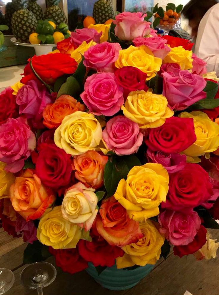 a vase filled with lots of different colored flowers