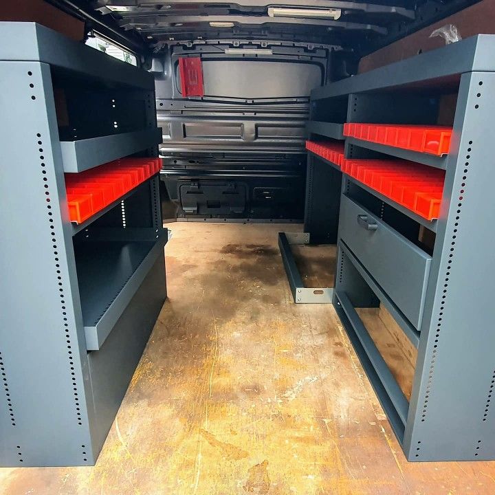 the inside of a van with red shelves