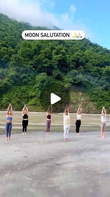 a group of people standing on top of a sandy beach holding hands in the air