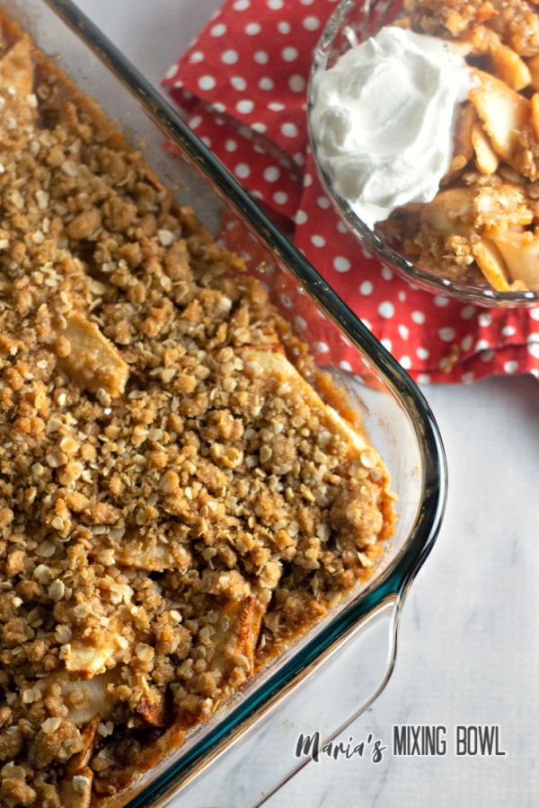 a casserole dish filled with baked goods next to a bowl of whipped cream