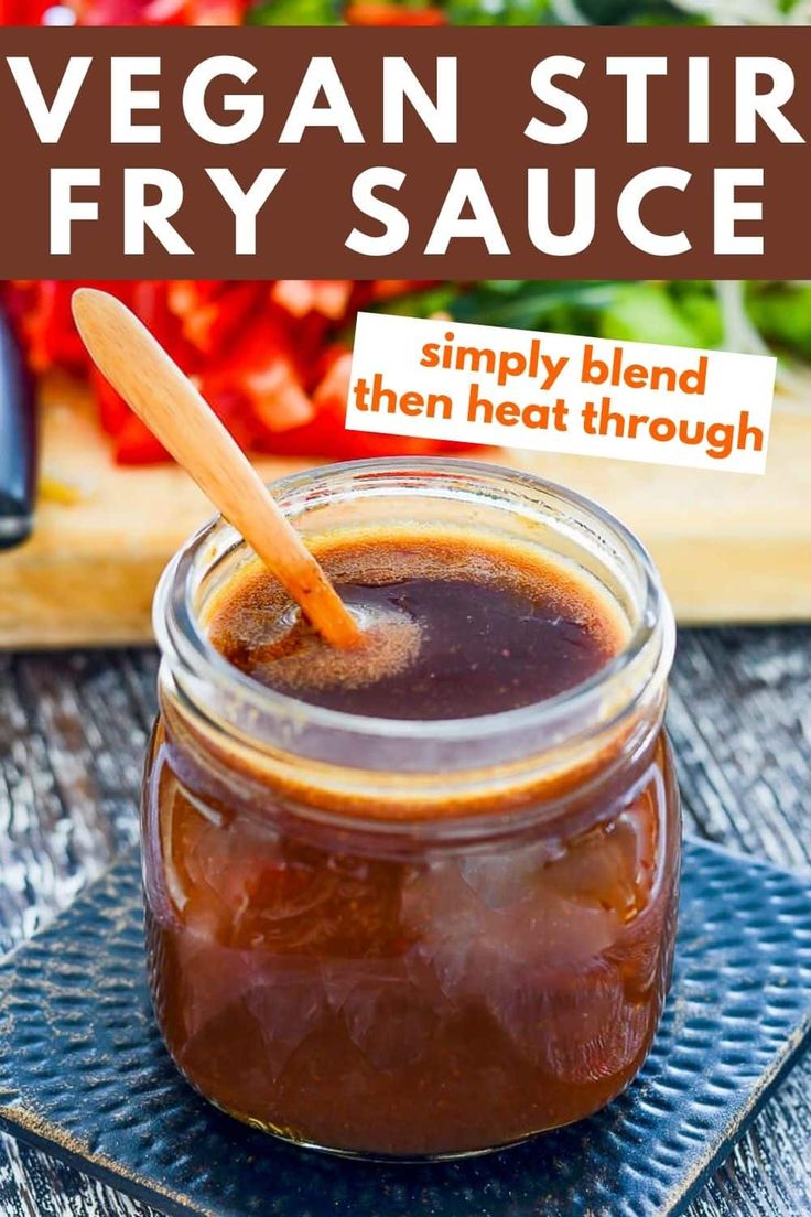 a glass jar filled with brown liquid sitting on top of a table next to a cutting board