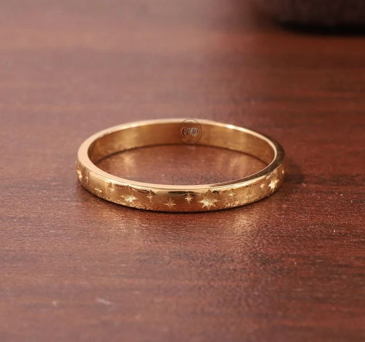 a close up of a gold ring on a wooden table