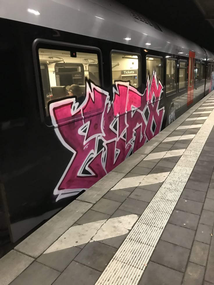 graffiti on the side of a train at a station