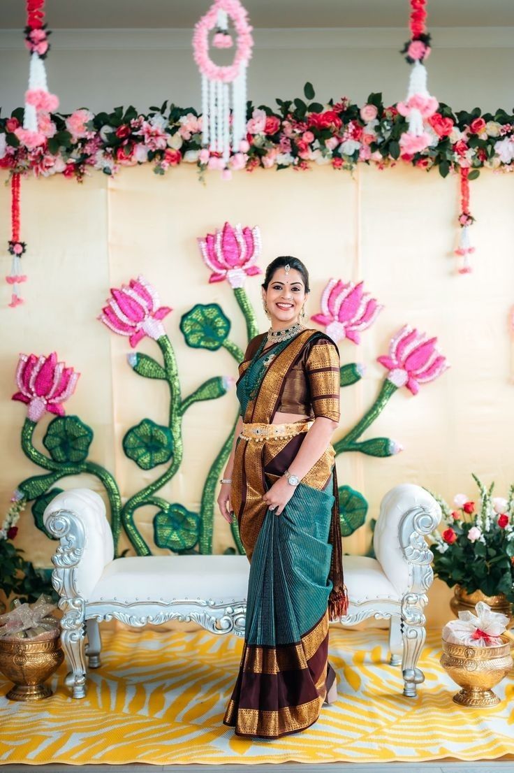 a woman standing in front of a wall decorated with flowers