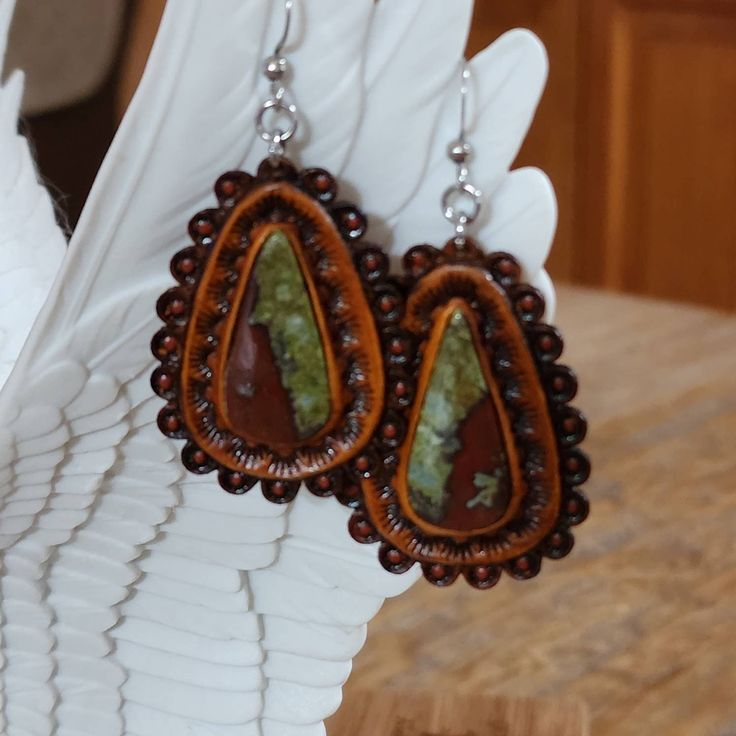 Hand picked unique cut gemstones pieces to make these standout one of a kind leather earrings.  -Your choice of Bloodstone and different variations of Turquoise  -Surgical Steel hooks -Stainless steel bails -Doubled leather -Briar brown finished  Find more of my rustic my hand made designs ## https://www.etsy.com/shop/KCsDesignsShop $ this site has coupon codes -message for any questions you may have Western Leather Earrings, Concho Earrings, Buffalo Nickel, Western Leather, Oyster Shell, Metal Work, Tooled Leather, Leather Cuffs, Make Design