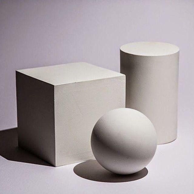 two white vases sitting next to each other in front of a box and ball