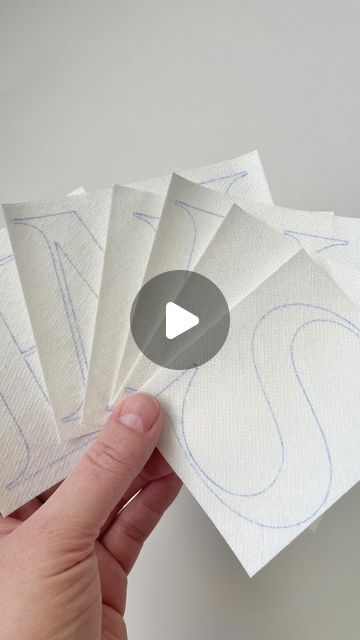 someone is holding five pieces of paper with the video below it that shows how to fold them