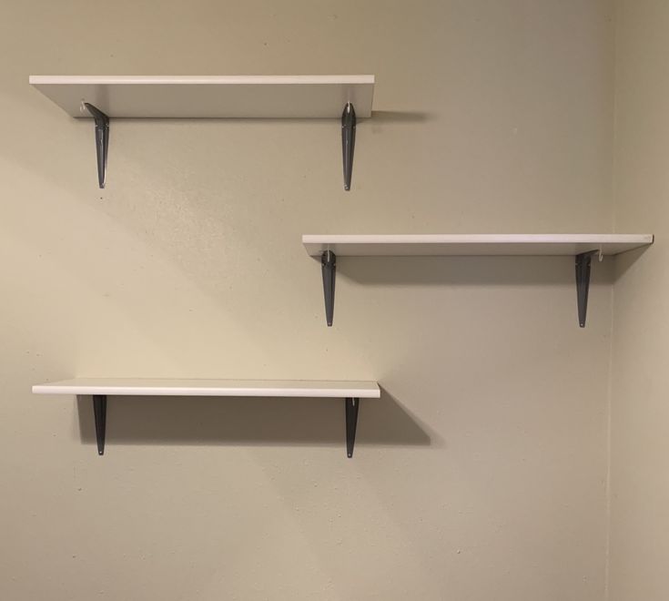 two white shelves are hanging on the wall