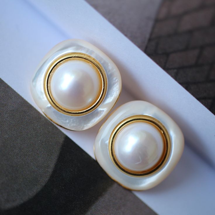 These stunning gold plated silver earrings feature a beautiful pair of hemisphere Mabe Pearl stones. With their intricate details and rich color, these push back studs are the perfect statement piece for any outfit. Handcrafted with care, these earrings are a true work of art and are sure to draw attention wherever you go. Whether you're looking for a unique gift or simply want to treat yourself. With their durable construction and timeless design, they're sure to become a beloved addition to yo Gold High Luster Classic Earrings, Classic White Earrings With High Luster, White Round Clip-on Earrings, White Classic High Luster Earrings, Classic White High Luster Earrings, Classic White Clip-on Pearl Earrings, White Gold Plated Clip-on Earrings, Classic Pearl White High Luster Earrings, Formal White High Luster Earrings