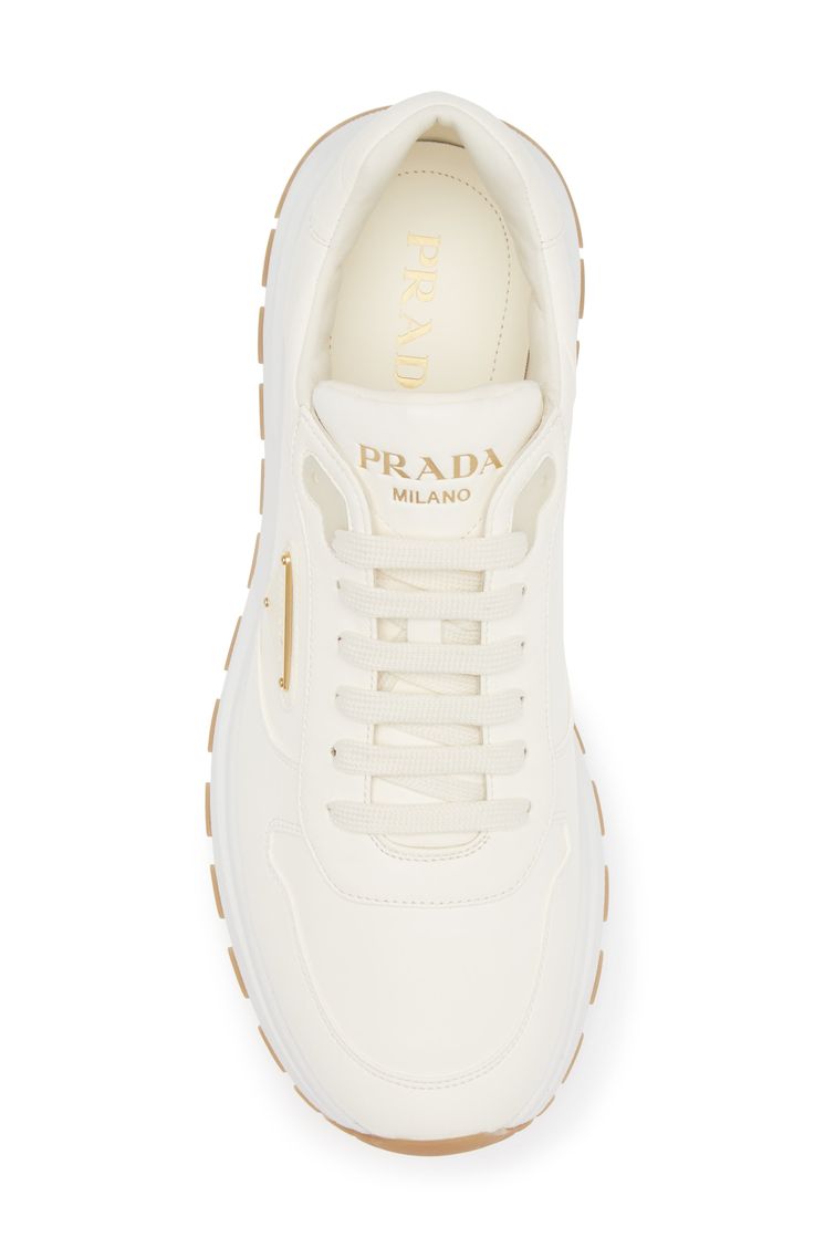 Prada takes a step to the future with a runner-style sneaker partially made from Re-Nylon, an industrial-inspired textile that can be endlessly regenerated. The iconic triangle logo first seen on trunks designed by Mario Prada in 1913 adds heritage style to your look. Lace-up style Removable insole Textile and leather upper/leather lining/rubber sole Made in Italy Designer Shoes Sporty Sneakers With Logo Plaque For Streetwear, Modern White Sneakers With Logo Plaque, Sporty Streetwear Sneakers With Logo Plaque, Designer White Sneakers For Running, Runner Style, Sneaker Men, Heritage Fashion, Triangle Logo, To The Future