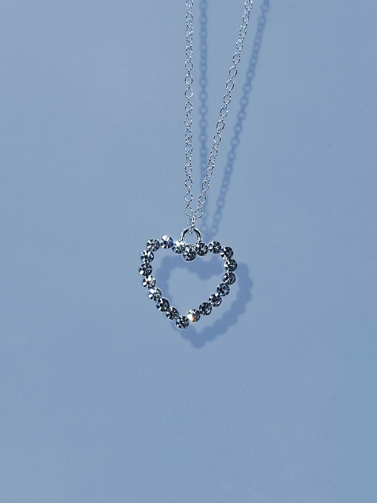 We have a beautiful rhinestone heart pendant on an adjustable stainless steel silver cable chain Silver Heart Necklace With Round Pendant And Clavicle Chain, Silver Heart Necklace With Clavicle Chain For Valentine's Day, Elegant Silver Crystal Heart Necklace, Valentine's Day Silver Heart Clavicle Necklace, Silver Rhinestone Clavicle Necklace For Valentine's Day, Valentine's Day Silver Rhinestone Clavicle Necklace, Silver Crystal Heart Necklace For Anniversary, Silver Heart-shaped Rhinestone Clavicle Necklace, Silver Double Heart Necklace With Clavicle Chain