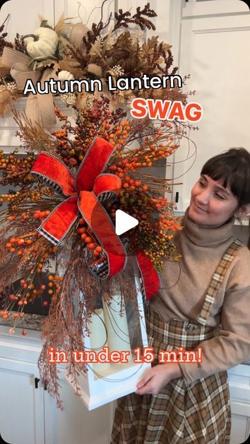 a woman is holding a box with an autumn wreath on it and the words, autumn lantern swag in under 15 minutes