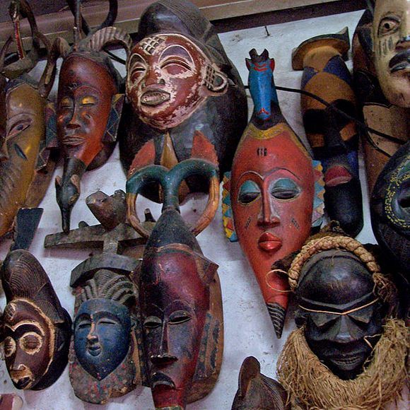 many masks are hanging up on the wall