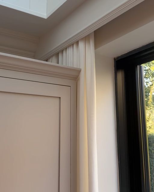 an open window in a room with white walls and black trim on the windowsill