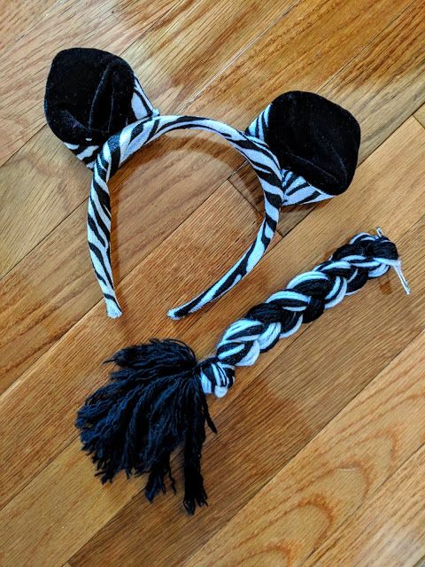 a pair of zebra print headbands with black and white hair ties on a wooden floor