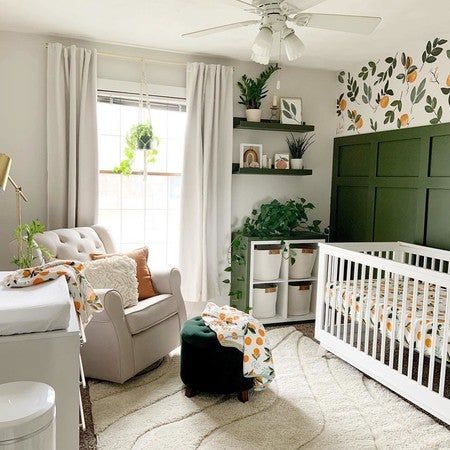 a baby's room is decorated in white and green with lots of greenery