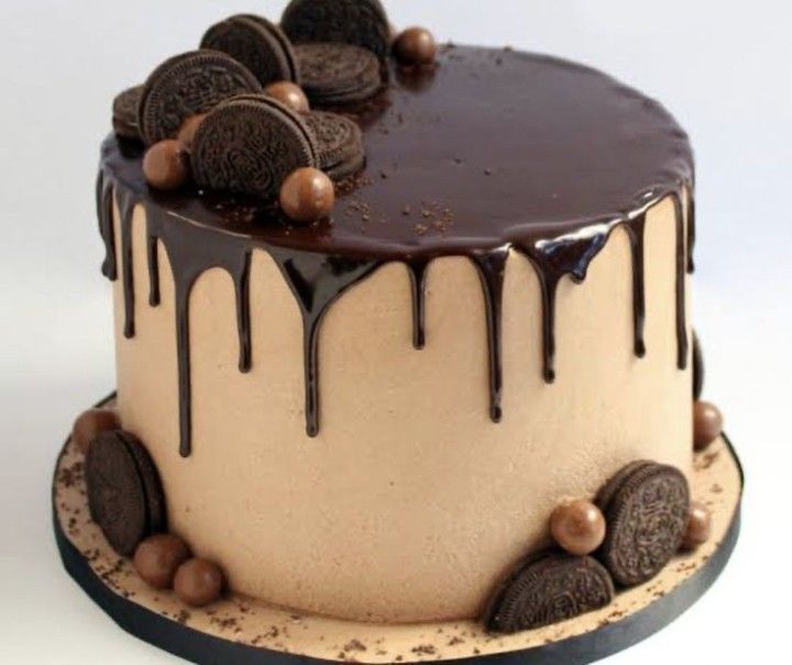 an oreo cookie cake with chocolate icing drizzled on the top