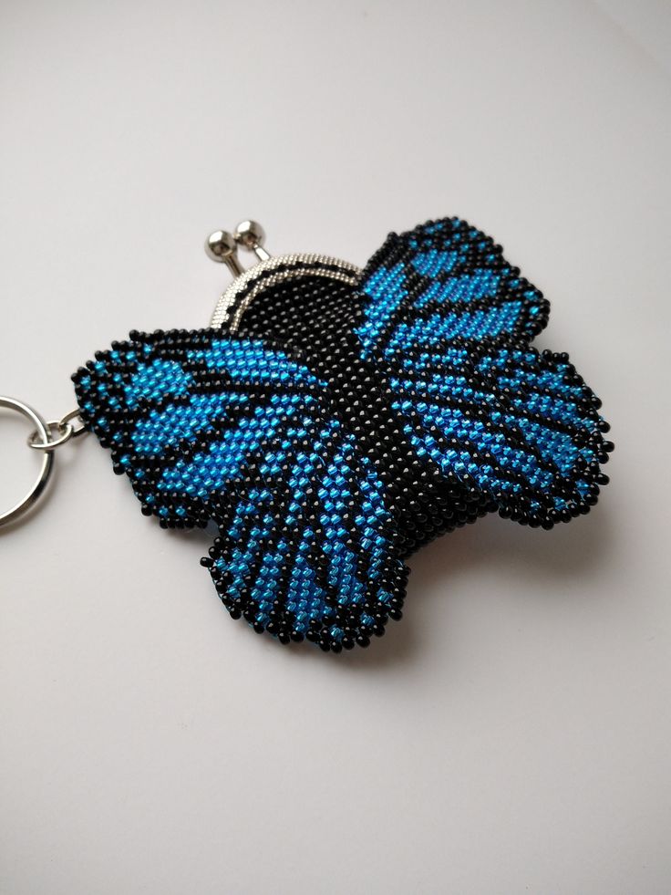 a beaded butterfly keychain is shown on a white surface with a metal ring