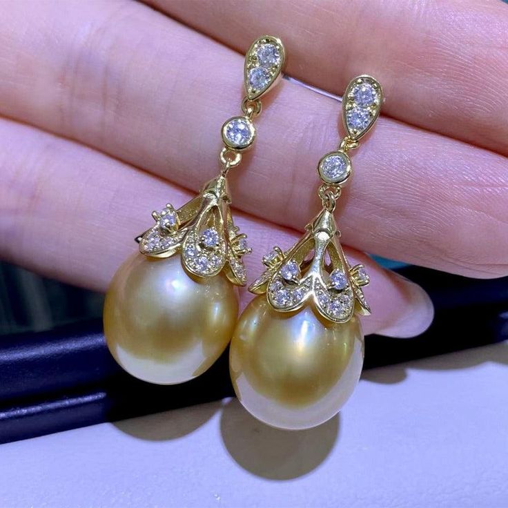 Golden South Sea Pearl 11.0-12.0 mm Add some shimmer and sparkle to your look with these Golden South Sea Pearl & Cubic Zirconia Luise Earrings. These earrings feature an elegant and classic gold button setting that provides the perfect backdrop for the fresh water pearl. These pearl earrings are sure to be a great addition to any outfit, whether you're dressing up or going casual. Their timeless style makes them an absolute must-have for any jewelry lover and they are a great way to update your Yellow Gold Diamond Earrings With Pearl Drop, High Luster Diamond Earrings For Formal Occasions, Luxury High Luster Earrings For Formal Occasions, Luxury Yellow Gold Pearl Earrings With Diamond Accents, Luxury Pearl Earrings With Prong Setting For Formal Occasions, Exquisite Pearl Earrings For Evening, Luxury Diamond Dangle Pearl Earrings, Luxury Yellow Gold Diamond Pearl Earrings, Exquisite Gold Diamond Pearl Earrings