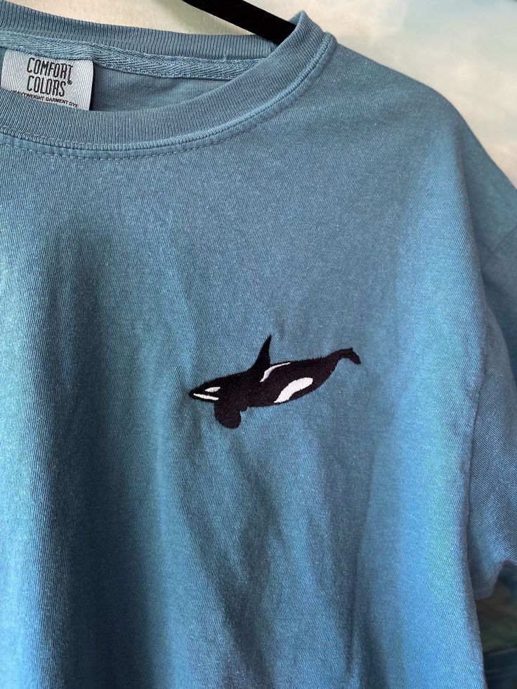 "Original Design Embroidered Orca T-Shirt! Lots of different color choices and sizes, this shirt is designed to be for Unisex but the sizing is in Men's, just check out the size chart and order accordingly! This Embroidered Orca Whale Comfort Colors shirt is part of my \"Ocean Creature Shirts\" collection. OTHER SHIRTS YOU MIGHT LIKE: LOOKING FOR THE SWEATSHIRT VERSION? https://www.etsy.com/listing/1601795282/orca-whale-embroidered-gildan-sweatshirt Interested in Embroidered Mom and Baby Orca shirt? See my other listing here: https://www.etsy.com/listing/1516341946/orca-whale-embroidered-bella-canvas Embroidered Orca Whales Mom of Two Comfort Colors Shirt: https://www.etsy.com/listing/1586621759/mom-of-two-embroidered-orca-shirt-orca If you're looking for a thick, structured tee that's als Whale Tee Shirt, Casual Embroidered Crew T-shirt, Casual Long Sleeve Shirt With Custom Embroidery, Blue Crew T-shirt With Embroidered Graphics, Blue Embroidered Crew T-shirt, Casual Crew Neck T-shirt With Custom Embroidery, Casual Blue Top With Embroidered Text, Blue Crew T-shirt With Custom Embroidery, Blue Crew Neck T-shirt With Custom Embroidery