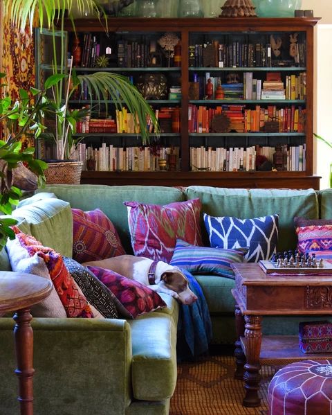 a living room filled with lots of furniture and bookshelf in the back ground