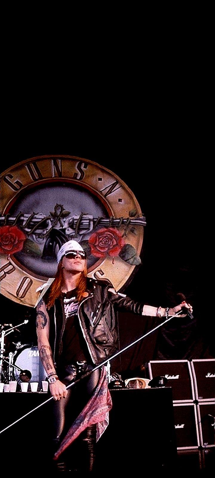 a woman with red hair and piercings standing on stage in front of a clock