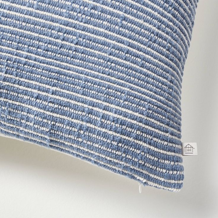 a blue and white striped pillow sitting on top of a table