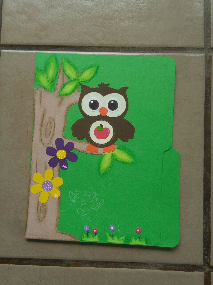 an owl is sitting on a tree branch with flowers in its beak and eyes open