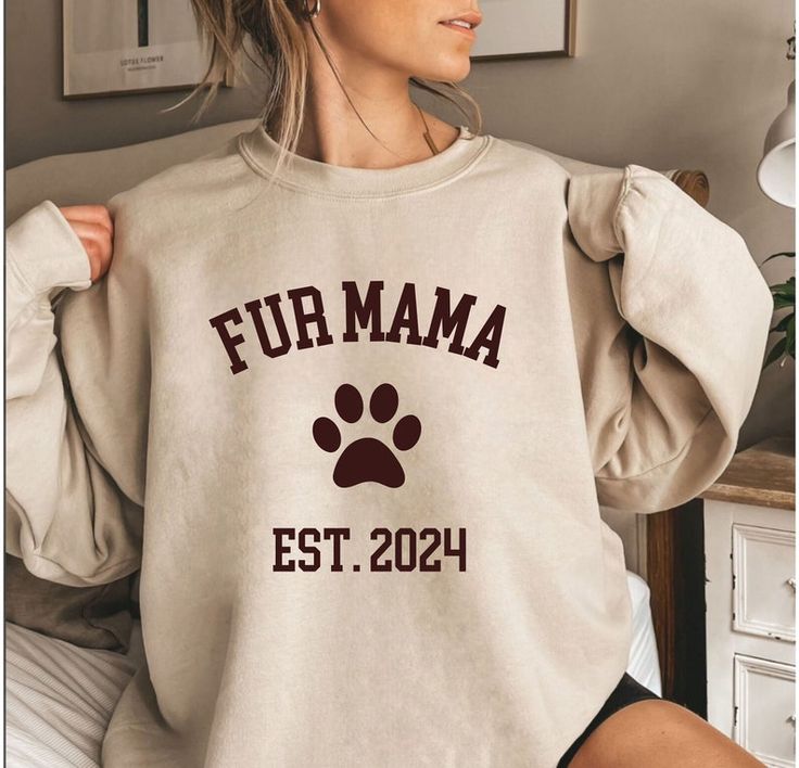 a woman wearing a sweatshirt that says fur mama est 2020