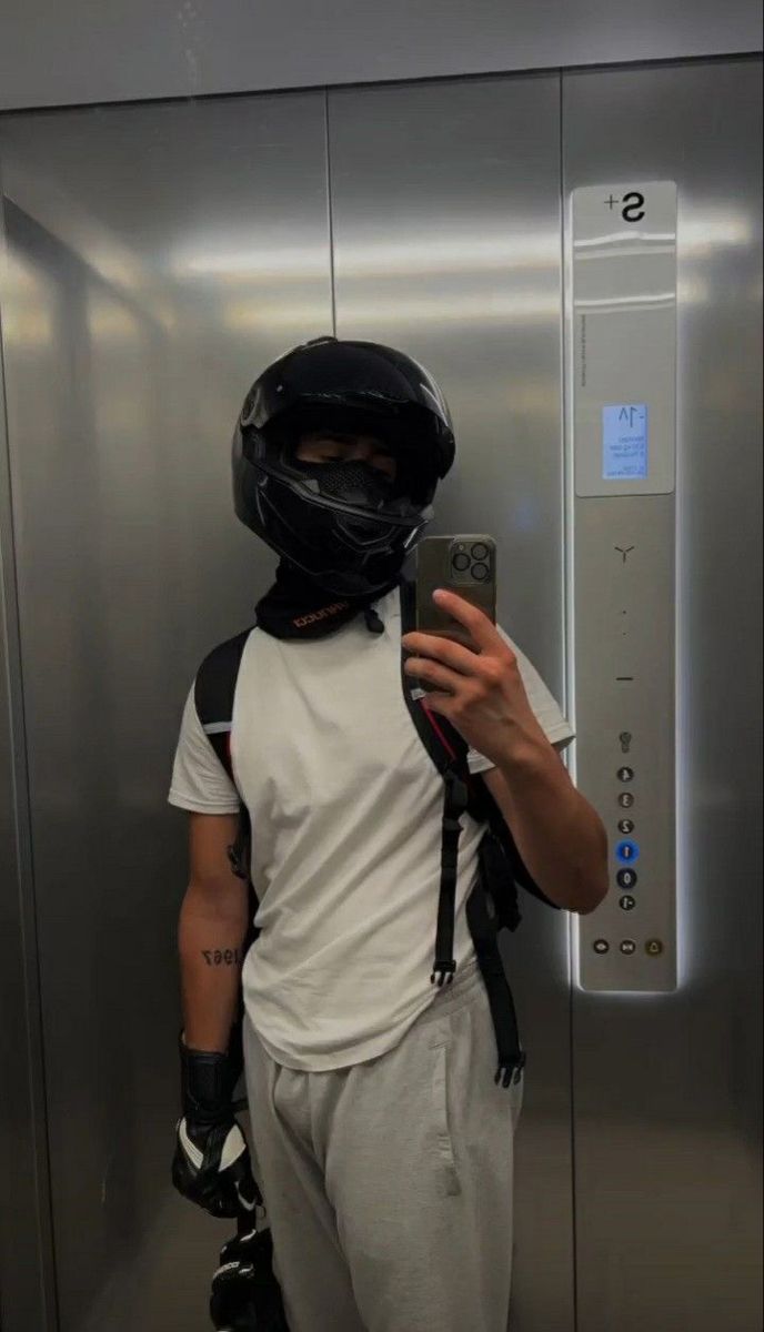 a man wearing a helmet and goggles taking a selfie with his cell phone