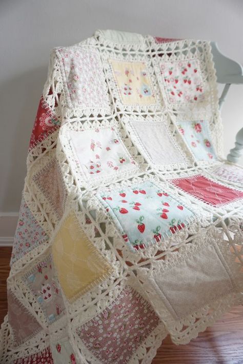 a white crocheted blanket sitting on top of a wooden floor next to a chair