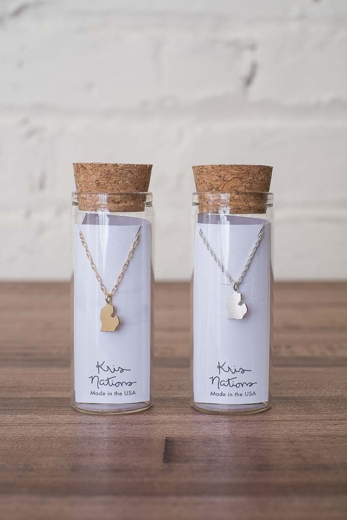 two small glass jars with necklaces in them