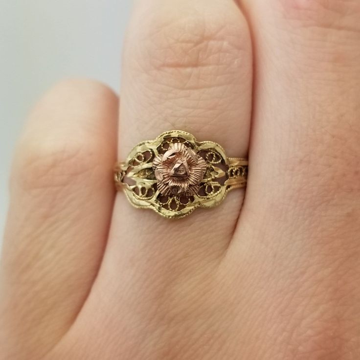 a close up of a person's hand with a gold ring on their finger