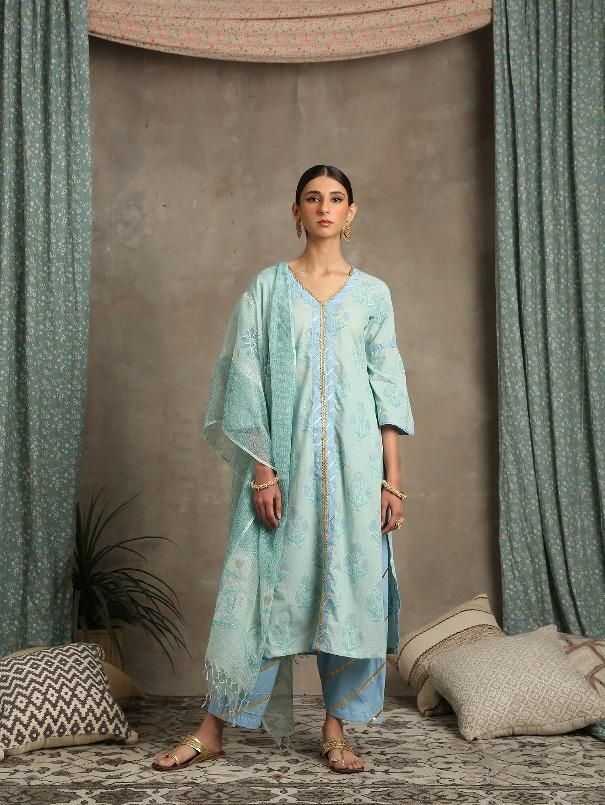 Set of 3 consists of kurta, dupatta and salwar Hand printed poppies in white and gold khari set on a sea green base. Straight v neck, bell sleeve kurta in cotton with hand-made magzi and gota detailing. Salwar - Cotton salwar set in a contrast blue with lehriya gota work Dupatta- Handwoven kota doria, block printed dupatta. Color - Turquoise Fabric - Cotton and Kota Doria Occasion - Festive Wear / Bridal Wear Fit - Straight, Relaxed and Comfortable Pattern - Printed Care - Dry Clean only Estimat Designer Turquoise Saree Sets, Light Blue Straight Kurta Salwar Kameez, Turquoise Bollywood Designer Wear Sets, Turquoise Bollywood Designer Sets, Bollywood Turquoise Saree Set, Festive Turquoise Sheer Dupatta, Green Block Print Lawn Suit With Straight Kurta, Semi-stitched Turquoise Sets With Dupatta, Green Lawn Suit With Block Print Straight Kurta