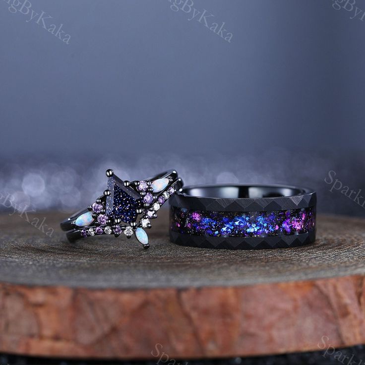 two rings sitting on top of a wooden table with purple and blue glitter in them