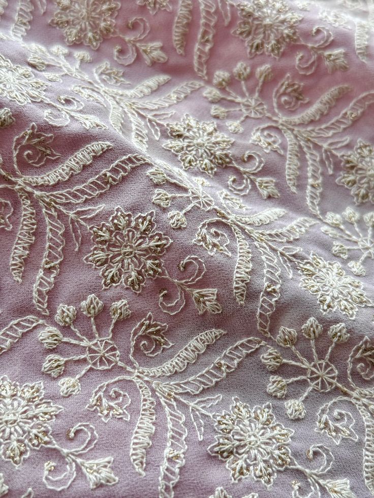 the fabric has been embroidered with white lace