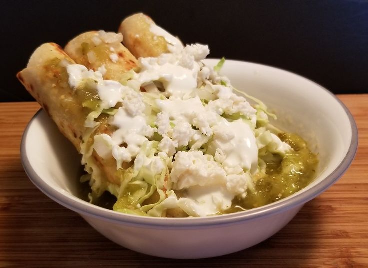 a white bowl filled with food on top of a wooden table