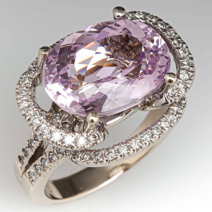 This kunzite ring is centered with one (1) oval mixed cut natural kunzite set into a four-prong setting. The ring is also accented with eighty-four (84), prong set, round brilliant cut diamonds. The ring measures 18.0mm at the top, rises 11.9mm above the finger, tapering to 3.5mm wide and 1.3mm thick at the base of the shank. It is currently a size 8.75. Elegant Morganite Rings For Formal Events, Elegant Morganite Ring For Formal Occasions, Exquisite Pink Sapphire Rings For Formal Occasions, Exquisite Pink Sapphire Rings For Formal Events, Luxury Pink Oval Topaz Ring, Formal Brilliant Cut Pink Sapphire Rings, Elegant Round Pink Sapphire Gemstones, Oval Morganite Ring For Formal Occasions, Luxury Pink Amethyst Ring For Formal Occasions