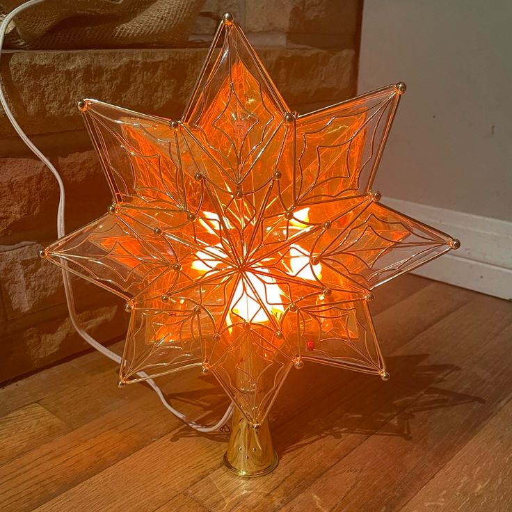 a star shaped light sitting on top of a wooden floor