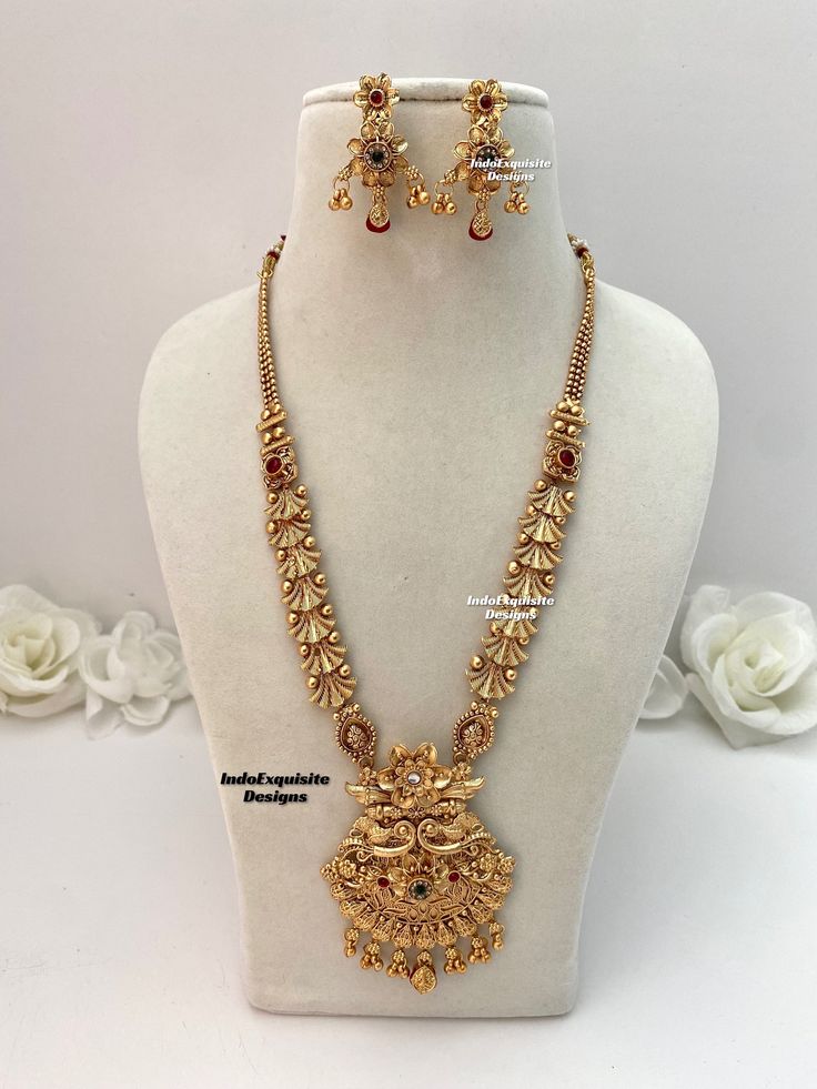 Matt gold finish Raani Haar(long necklace) comes with Earrings/bridal jewellery/south Indian long necklace Set/Rajwadi Rani Haar/Guttapusalu necklace/ one 1 gram gold/Ruby Green  All items are shipped from Brampton, Ontario, Canada. If you need your item by a certain day, please reach out to us for express delivery option before placing the order so that we can update the shipping for you. Standard shipping/delivery timeline Below are the estimated delivery times after the order is shipped/dispatched.  ---> USA delivery timeline * 3-5  business days to major urban centers in USA. It may take 2-3 days extra to remote locations ---> Canada delivery timeline  * 2-3 business days - GTA  & Montreal  * 2-4  business days - Rest of Ontario/Quebec * 4-6 business days-  Rest of Canada (Please consi Medium Size Necklace Gold, Heavy Gold Pendent Designs, Bridal Necklace Set Gold, Gold Rani Haar Indian, Raani Haar Gold Jewellery Designs, Rani Haar Gold Indian Bridal, Gold Bridal Jewellery Indian, Long Sets Gold Jewellery, Rani Haar Gold Jewellery Designs