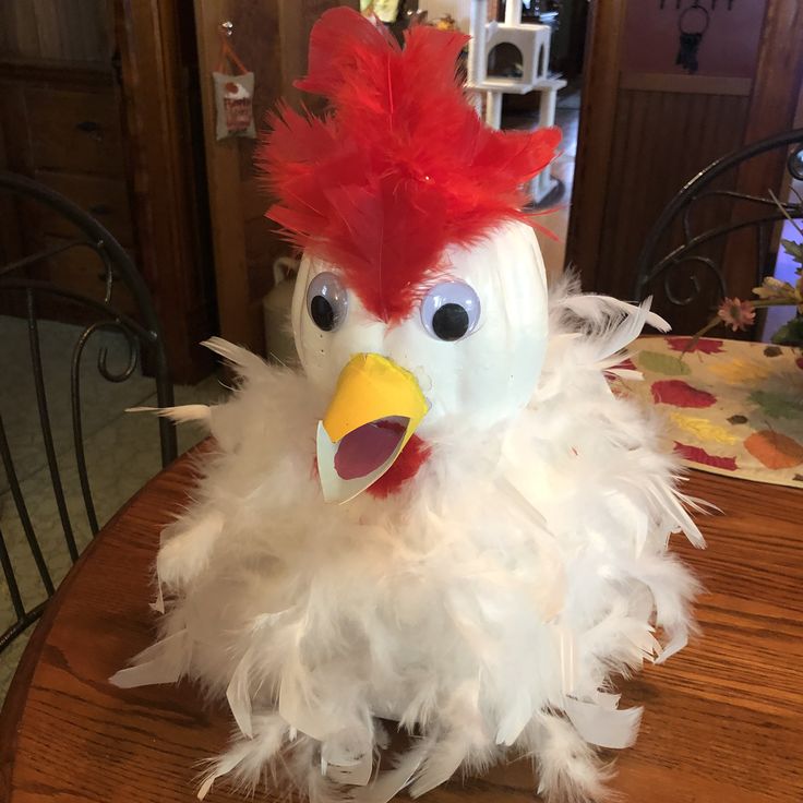 a white and red bird sitting on top of a wooden table