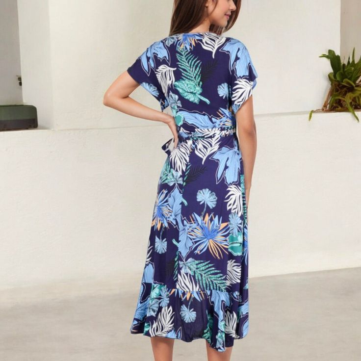 Elevate your summer wardrobe with the Anna-Kaci Women's Tropical Print High-Low Wrap Dress. This eye-catching dress features a vibrant tropical print that exudes island vibes, perfect for warm-weather adventures. The wrap design offers a flattering fit, accentuated by a waist tie that cinches beautifully at the waist. Flutter sleeves add a touch of femininity, while the high-low hemline provides a playful yet elegant silhouette. Whether you're headed to a beachside brunch or a casual day out, th Summer Tropical Print Midi Dress For Day Out, Summer Midi Dress With Tropical Print, Summer Tropical Print Midi Floral Dress, Summer Tropical Print Midi Dress, Casual Tropical Print Midi Dress For Summer, Tropical Short Sleeve Maxi Dress For Spring, Summer Vacation Tropical Print Midi Dress, Summer Vacation Midi Dress With Tropical Print, Tropical Printed Dress For Brunch