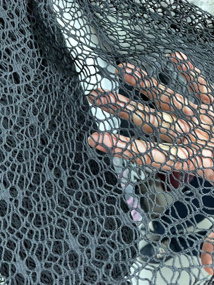 a close up of a person's hand holding something in a netted material