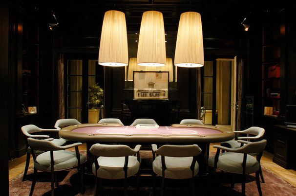 a large table with chairs and lamps in a room that has dark wood paneling on the walls