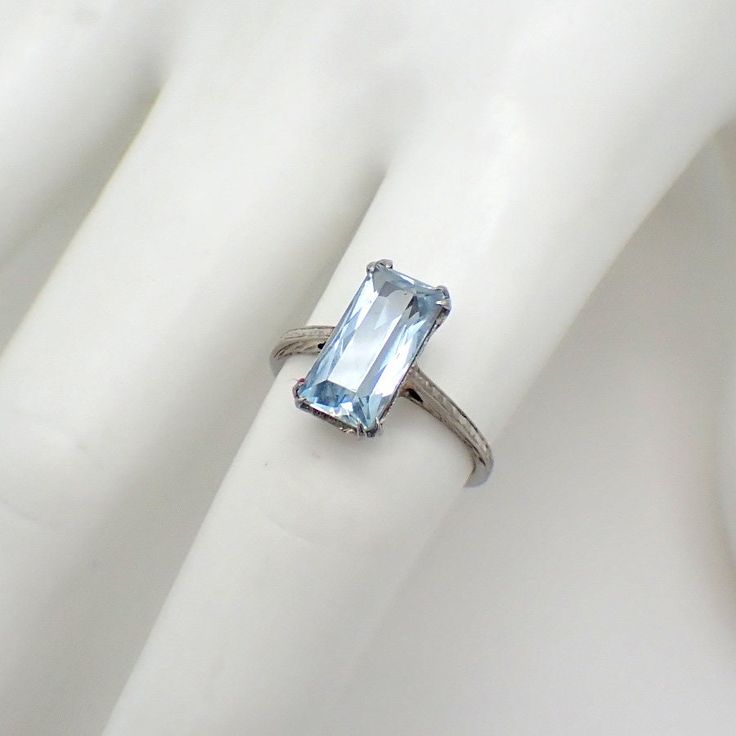 Art Deco 18K (.750) white gold ring with emerald-cut Aquamarine stone centerpiece. The stone is 2.5ct, measuring 12mm x 6.1mm x 4.8mm. This marvelous ring is a size 6 and 13 mm at the widest. EA3171 Formal Octagon Sapphire Ring In Platinum, Modern Topaz Ring With Rectangular Stone For Formal Occasions, Modern Formal Topaz Ring With Rectangular Stone, Platinum Baguette Cut Gemstone Ring, Platinum Rings With Baguette Cut Gemstone, Baguette Cut Platinum Gemstone Rings, Platinum Rings With Emerald Cut Gemstone, Timeless Rectangular Prong Set Emerald Ring, Timeless Rectangular Emerald Ring With Prong Setting