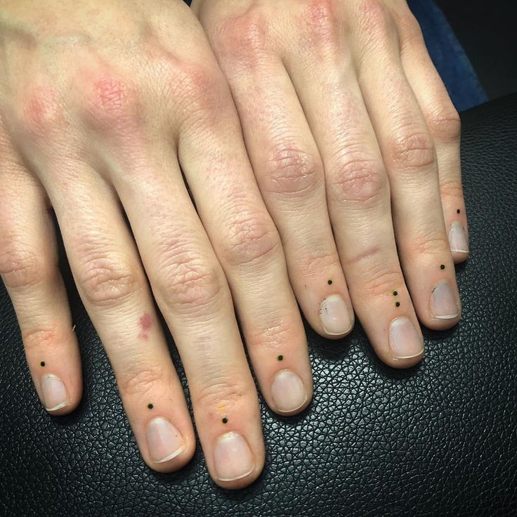 two fingers with small black dots on them