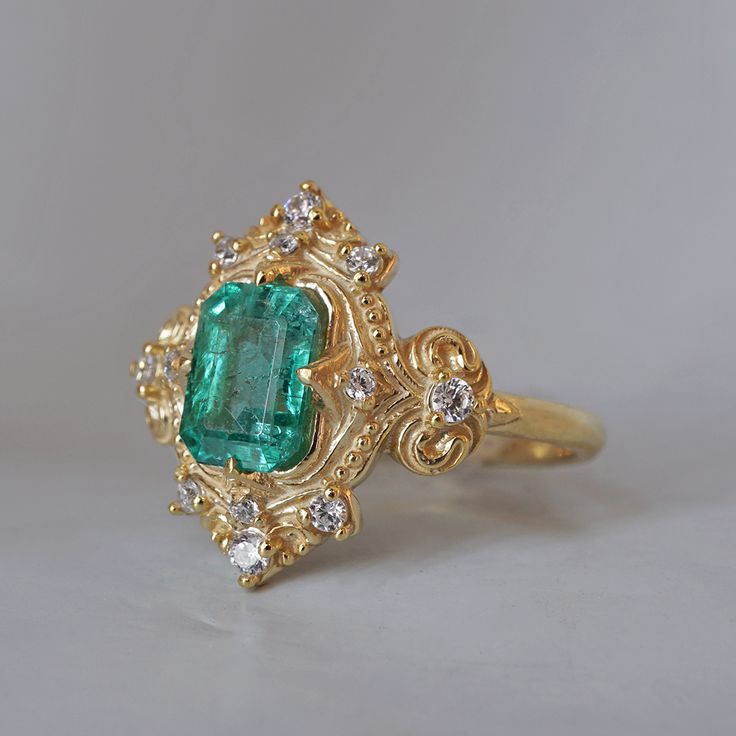 Read about our payment plans before proceeding. Palais d'Émeraude: A Parisian Royal Masterpiece Introducing the Emerald Palais Diamond Ring, an exquisite ring that captures Parisian elegance and sophistication. At its center, a lush emerald evokes the opulence of royal gardens. Inspired by Parisian palaces, this ring features delicate curves and ornate details that wrap around the vibrant emerald. The meticulous craftsmanship makes it a true masterpiece, fit for royalty. "Palais" translates to "Palace," reflecting the regal beauty and timeless charm of this piece. The emerald symbolizes rebirth, love, and fortune, elegantly embraced by the intricate band. All orders come in our Tippy Taste ring box. This ring is handmade and designed in NYC. 14K or 18K solid gold Natural emerald-cut emeral Fine Jewelry Emerald Ring With Intricate Design, Luxury Diamond Ring With Emerald Accent Stones, Emerald Ring With Intricate Design, Luxury Emerald Ring With Accent Stones, Luxury Emerald Birthstone Ring, Yellow Gold Emerald Ring With Intricate Design, Fine Jewelry Emerald Ring With Intricate Design For Wedding, Formal Emerald Ring With Intricate Design, Wedding Emerald Ring With Intricate Design