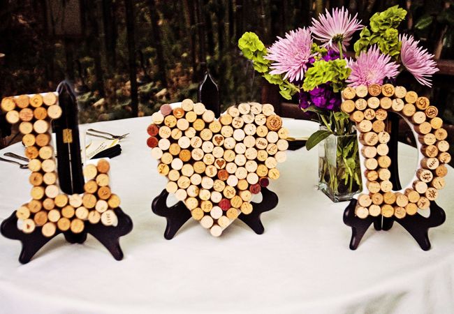 three wine corks shaped like the word i love you on a table with flowers